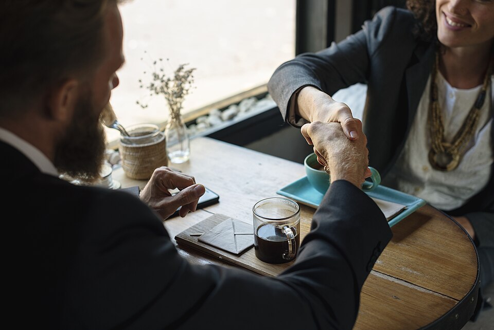 Two people shaking hands in a business setting