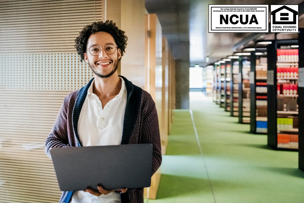 Smiling man holding laptop